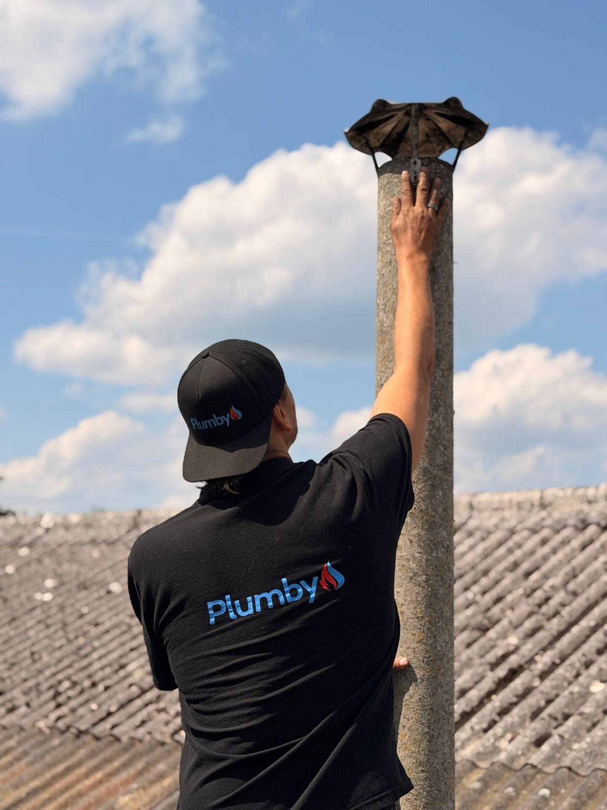 Ramonage de cheminée sur toiture par un technicien Plumby